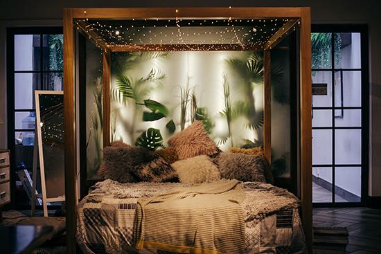 A peaceful bedroom design with fairy lights, plants and neutral tones. 